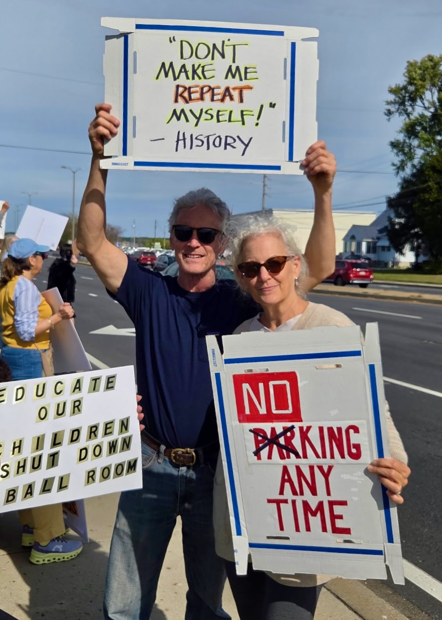 The author and her husband hold protest signs at a No Kings rally.