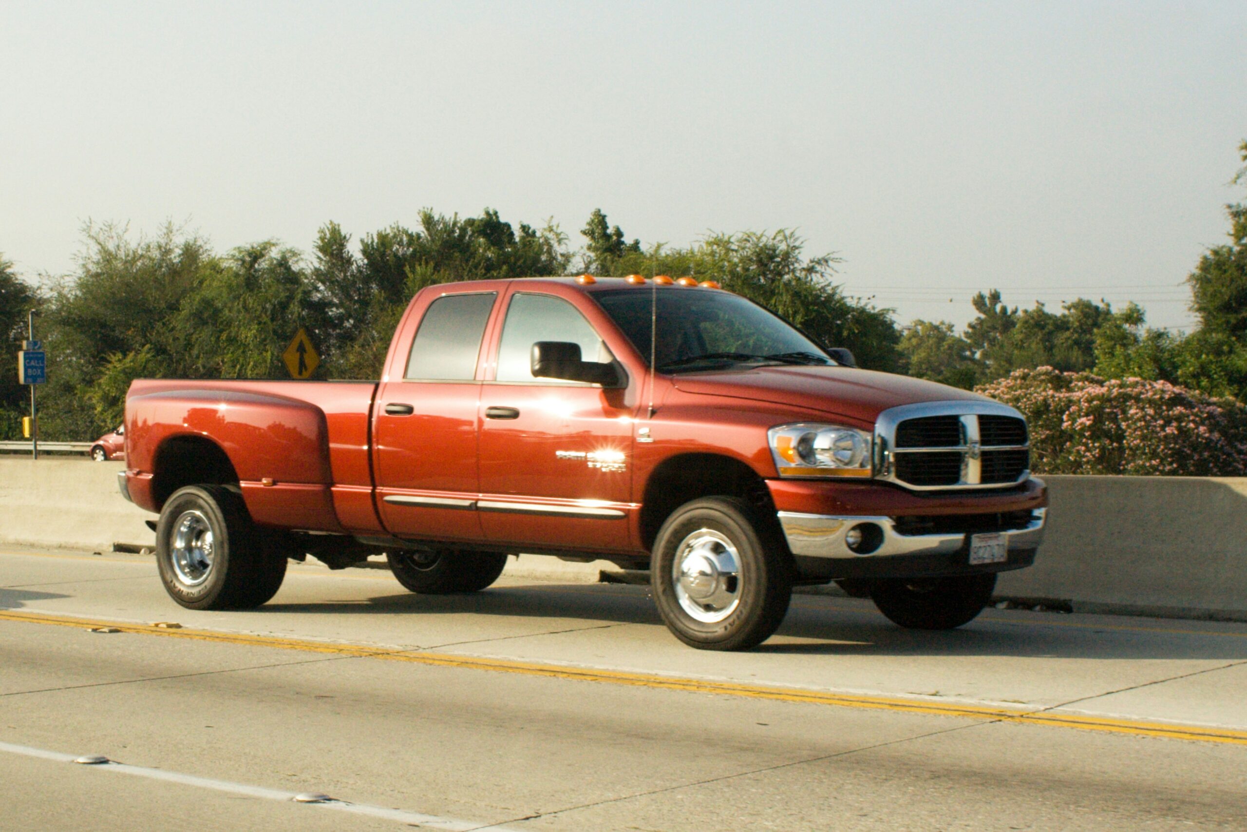 A red pickup truck moving down a highway