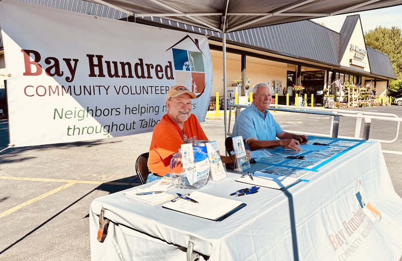 IMG 0957 2 Robert Blaschke, left, and Rich Ritterman, project managers for Bay Hundred Community Volunteers, man the promotional booth outside St. Michaels Market on June 6. The market donanted five percent of its Saturday sales to the Bay Hundred group.